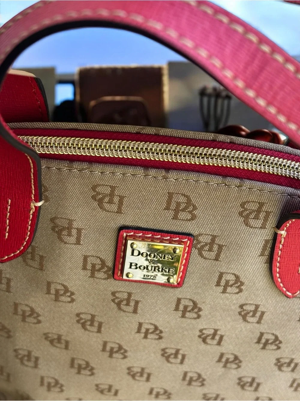 Dooney & Bourke Signature monogram satchel features vibrant pink leather trim